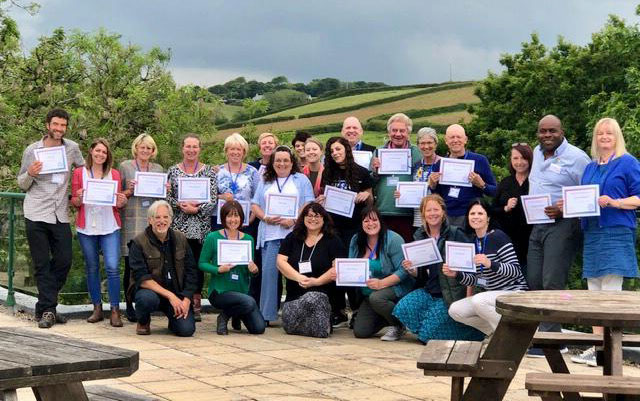 The smiling participants of the first UK "ASK" Workshot are assembled and proudly showing their certificates.